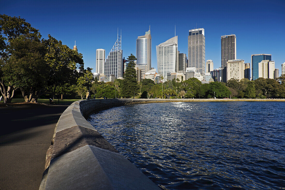 Seawall at Farm Cove with skyline and harbour on a sunny day in Sydney, Australia