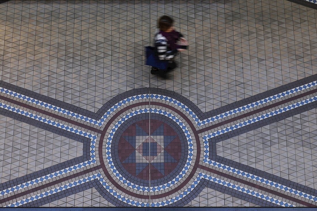 Person, die auf dem Mosaikfliesenboden im Queen Victoria Building im Central Business District von Sydney, Australien, geht