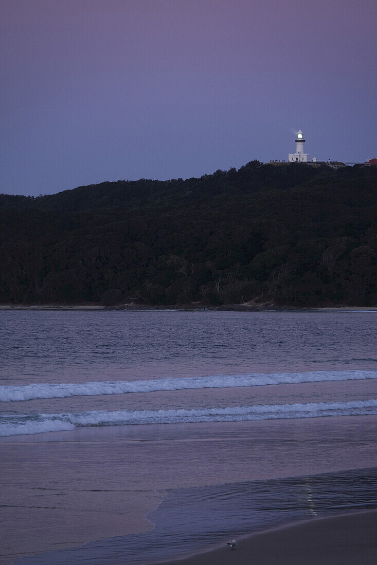 Cape Byron Lighthouse auf der Hügelspitze beleuchtet in der Abenddämmerung in Byron Bay in New South Wales, Australien