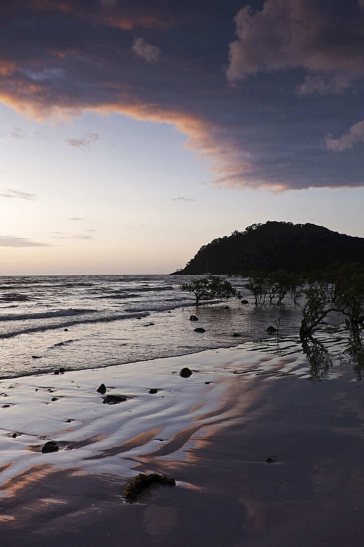 Silhouette of coastal shoreline and beach at Cape Tribulation at sunrise in Daintree National Park, Australia