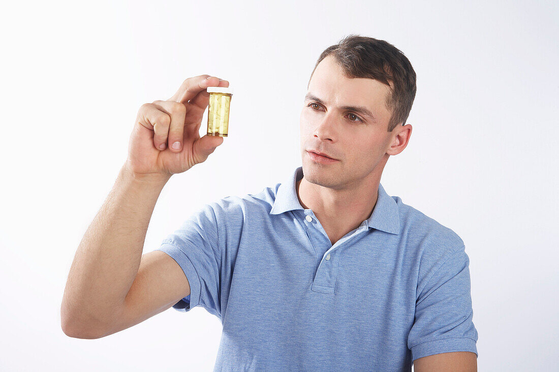 Man Looking at Pill Bottle
