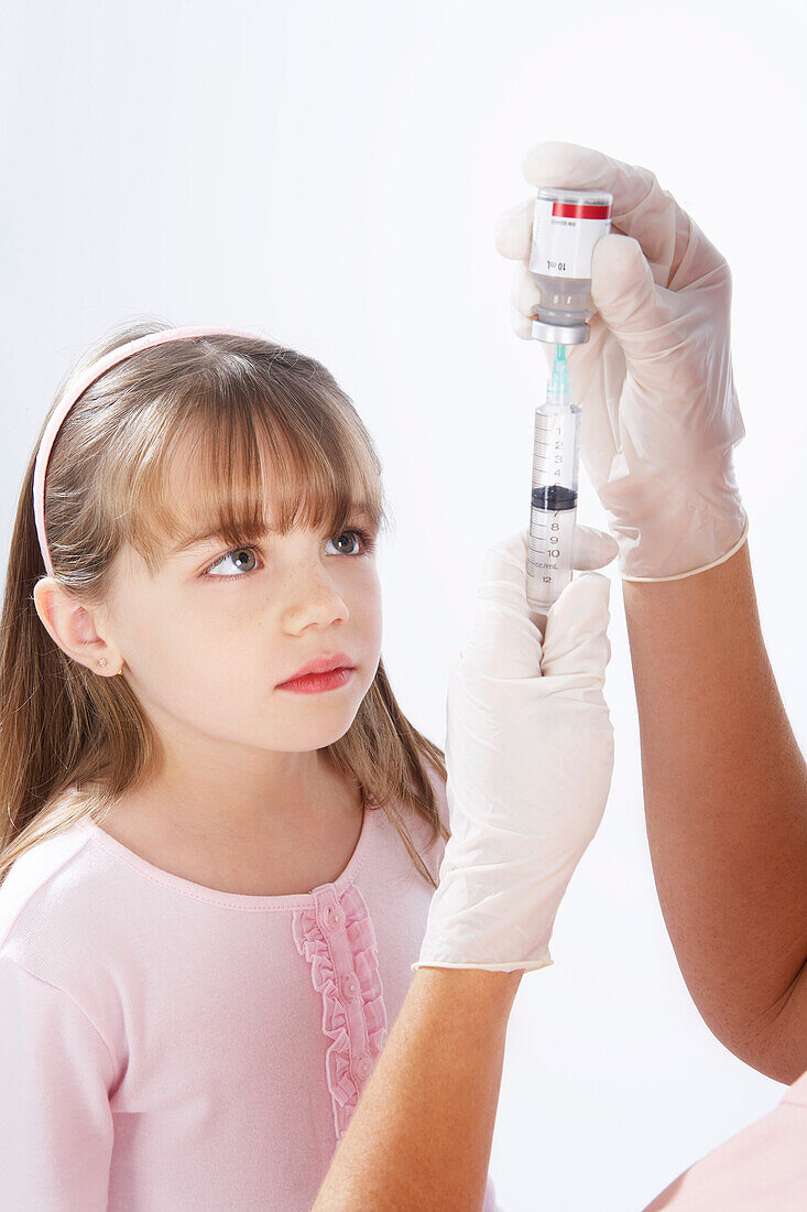 Little Girl Watching Nurse Prepare a Needle