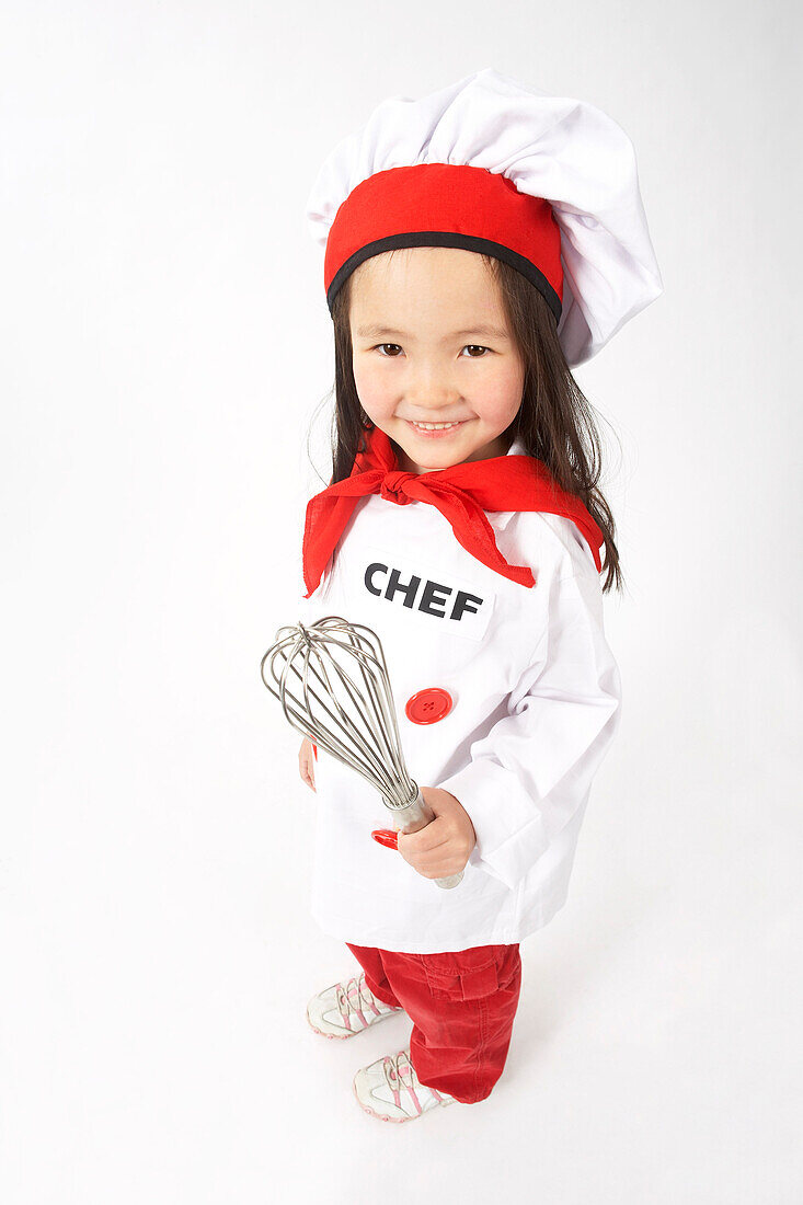 Little Girl Dressed Up as a Chef Holding a Whisk