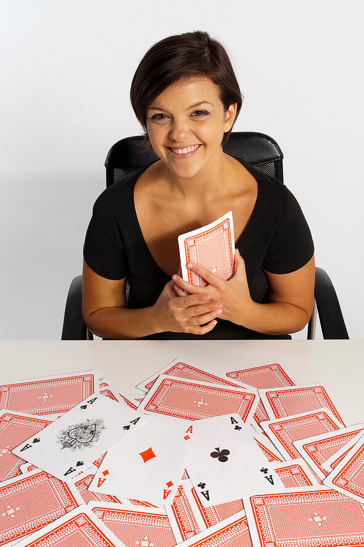 Mittelerwachsene Frau beim Zaubertrick mit Kartenspiel