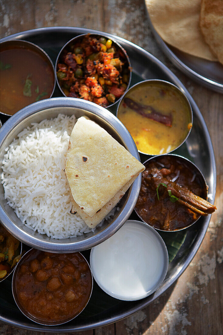 Thali, Rasam, Chana Masala, Kadai Bhindi, Gemischtes Gemüsecurry, Sambhar, Joghurt, Basmati-Reis und Chapati