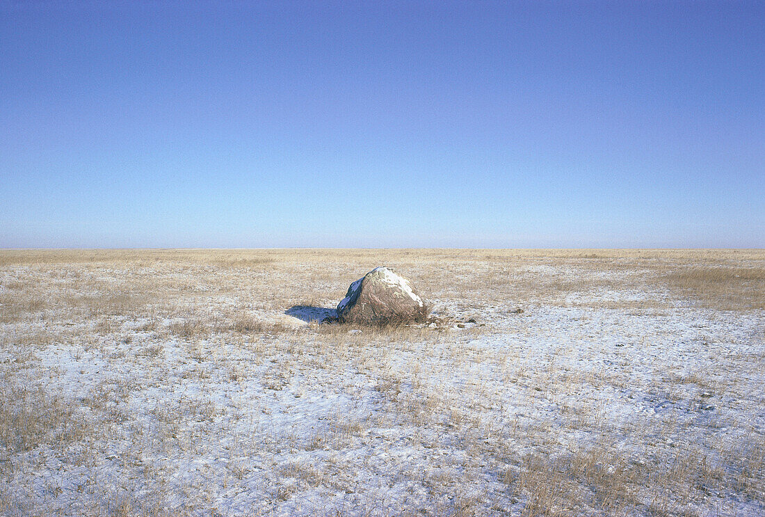 Großer Fels in verschneitem Feld bei Loring, Montana, USA