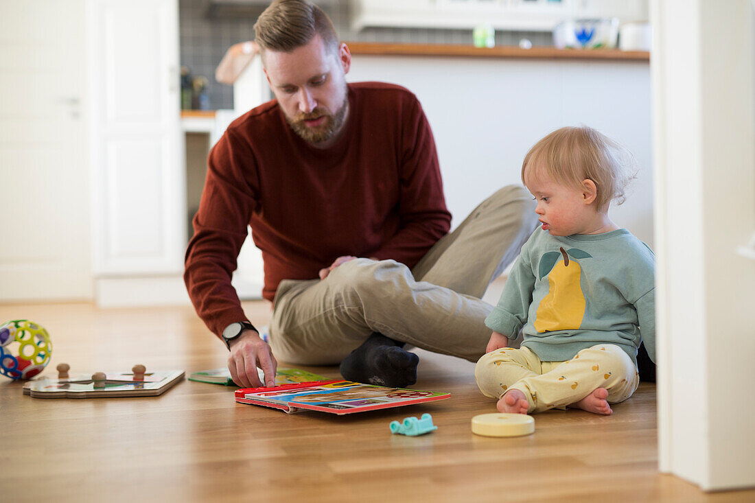 Father and toddler with down syndrome playing