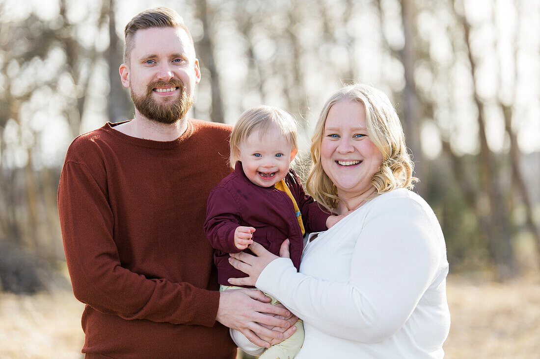 Outdoor portrait of family with baby with down syndrome