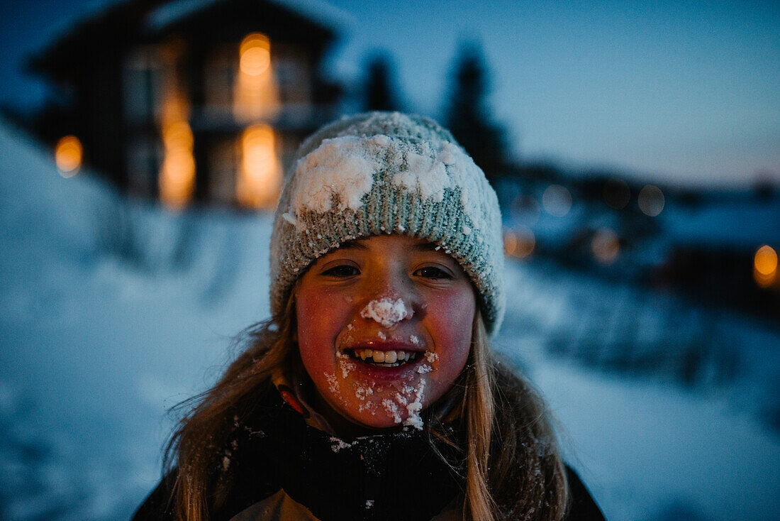 Happy girl covered in snow looking at camera