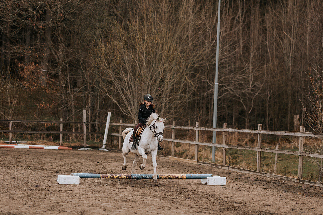 View of girl horseback riding