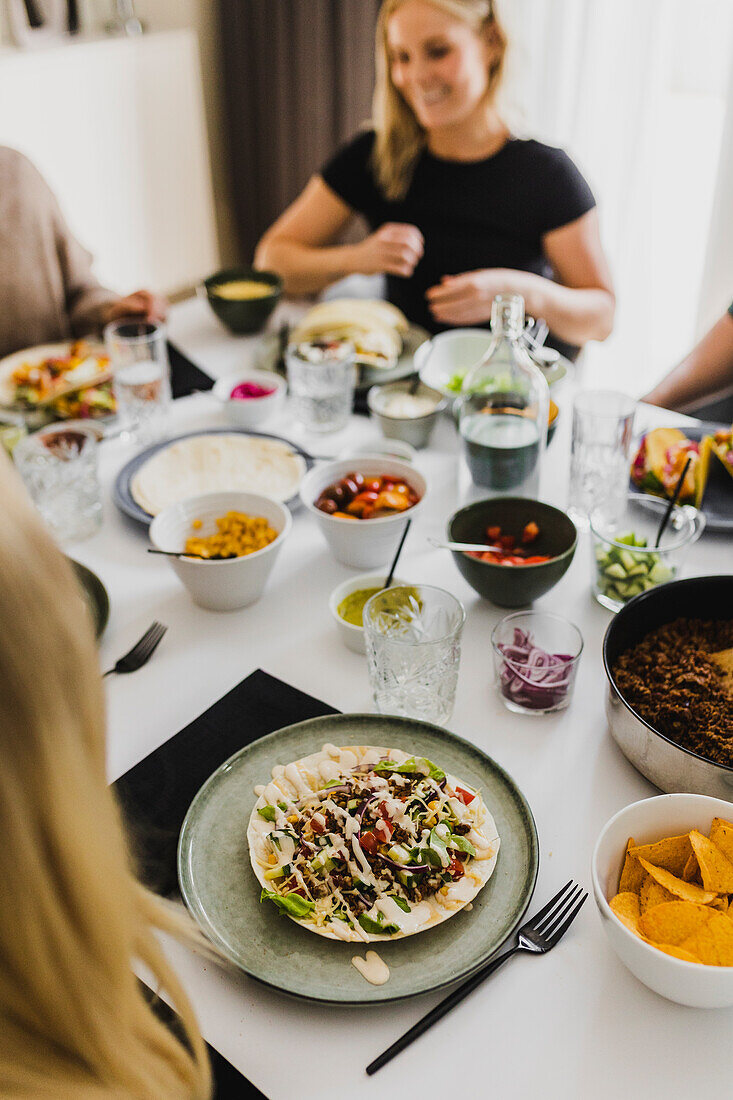 Group of friends eating Mexican food at home