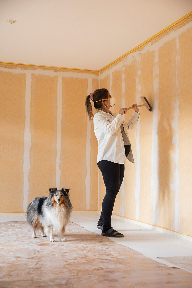 Pregnant woman brushing walls before painting