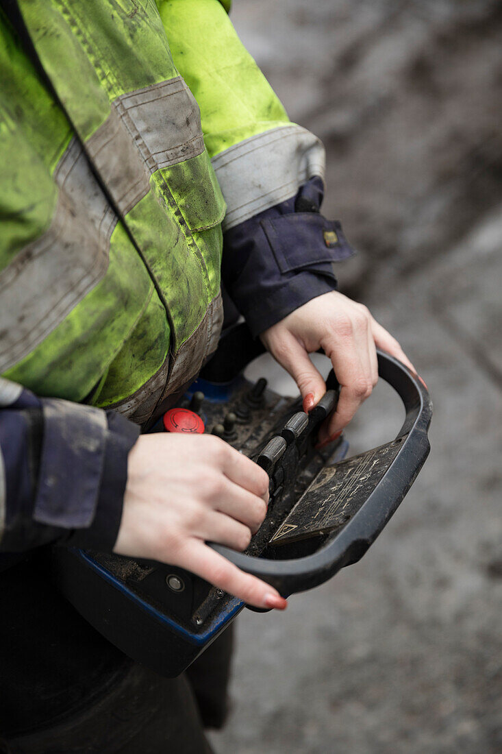 Close-up of construction worker holding controller