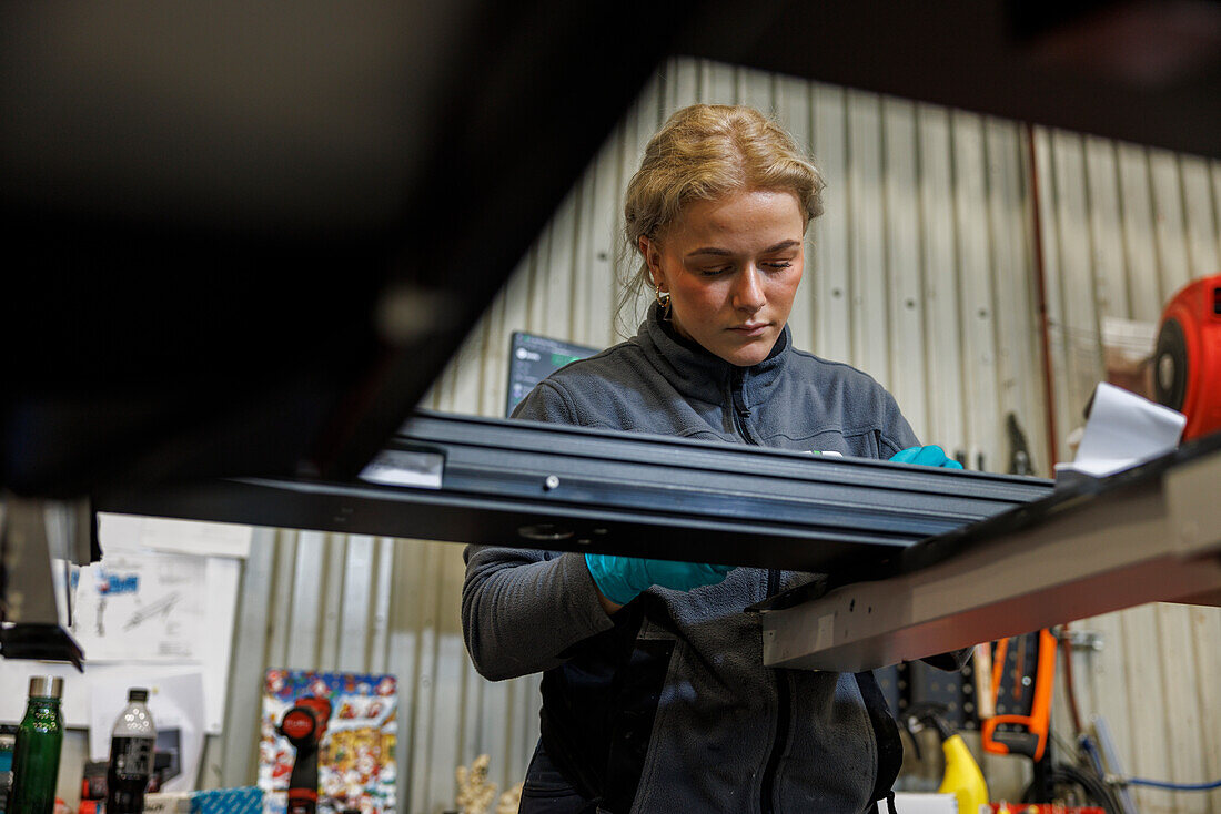 Junge Industriearbeiterin bei der Arbeit in einer Fabrik