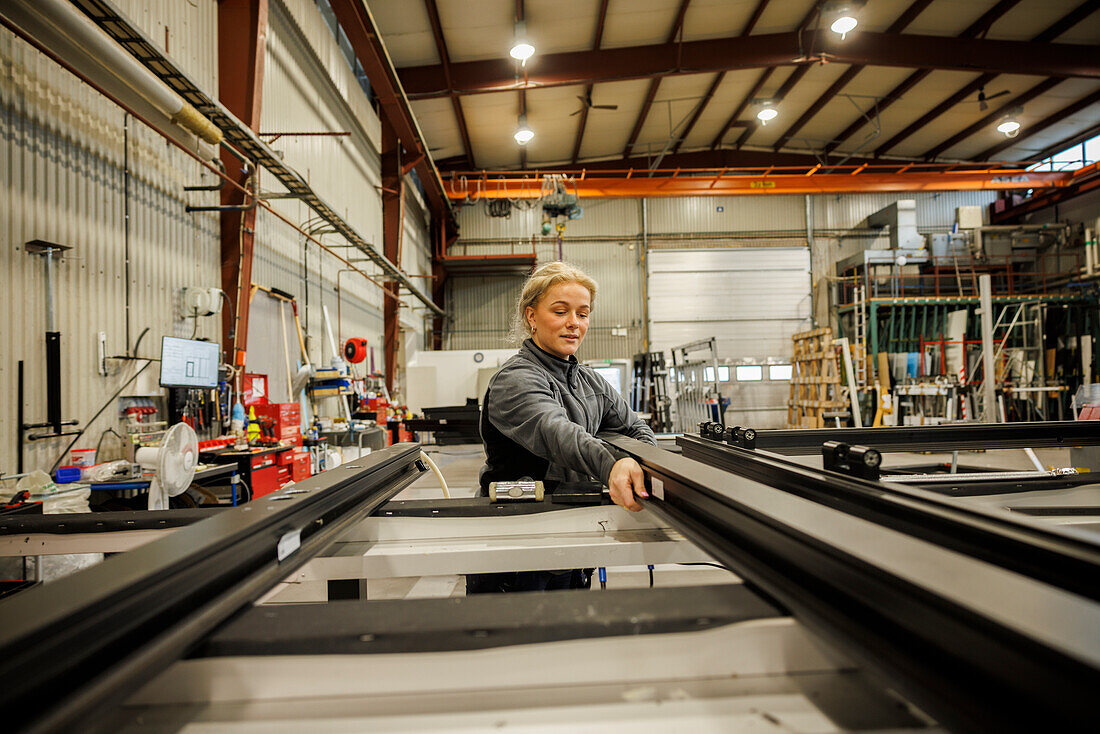 Young female industrial worker working in factory