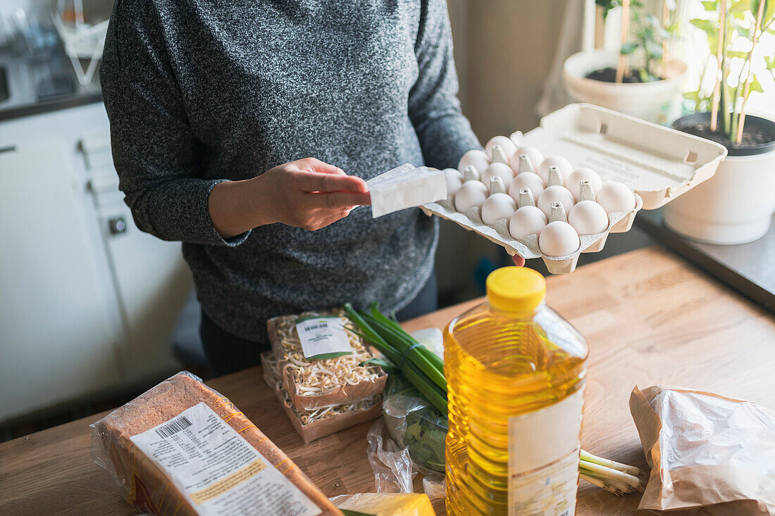 Frau prüft Kassenbon im Supermarkt während der Inflation mit Preisanstieg bei Lebensmitteln und Konsumgütern
