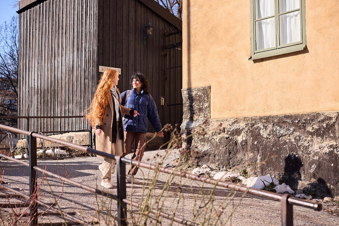 Female friends walking together ourdoors on walkway in city