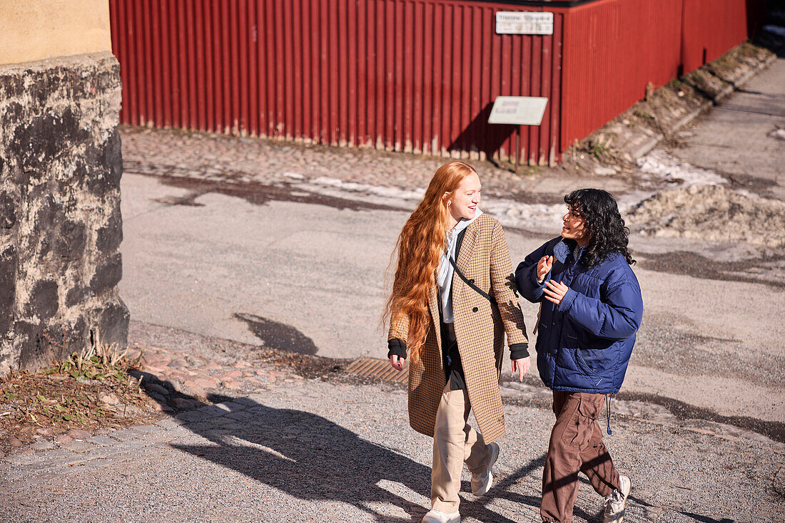 Female friends walking together ourdoors on walkway in city