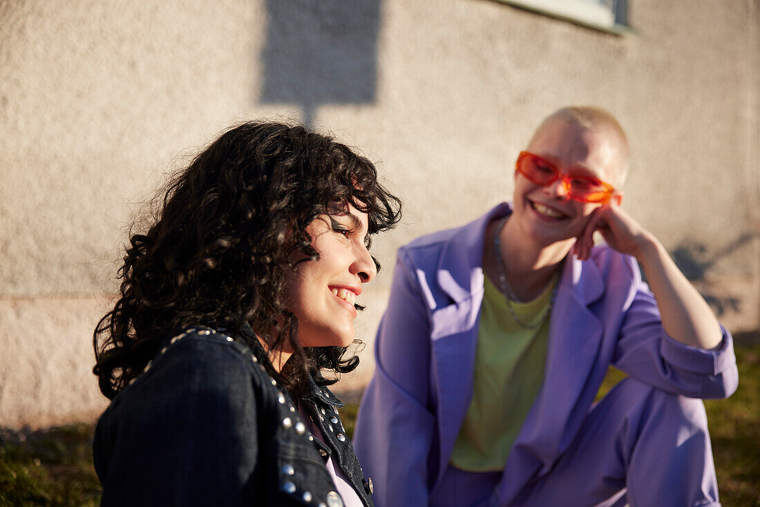 Smiling woman looking away, her female friend in background