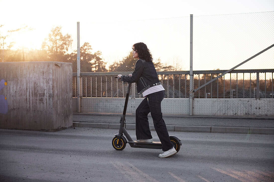 View of young woman riding scooter