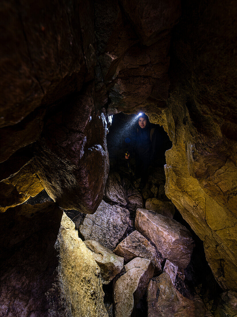 View of man exploring cave