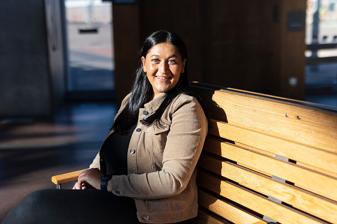 Smiling woman sitting on back at train station