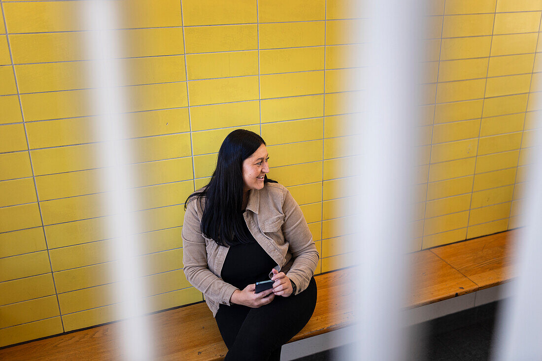 Smiling woman sitting and holding cell phone