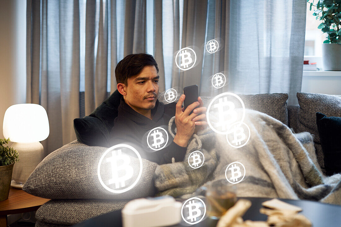Mann prüft Bitcoin-Kryptowährungskurse am Telefon