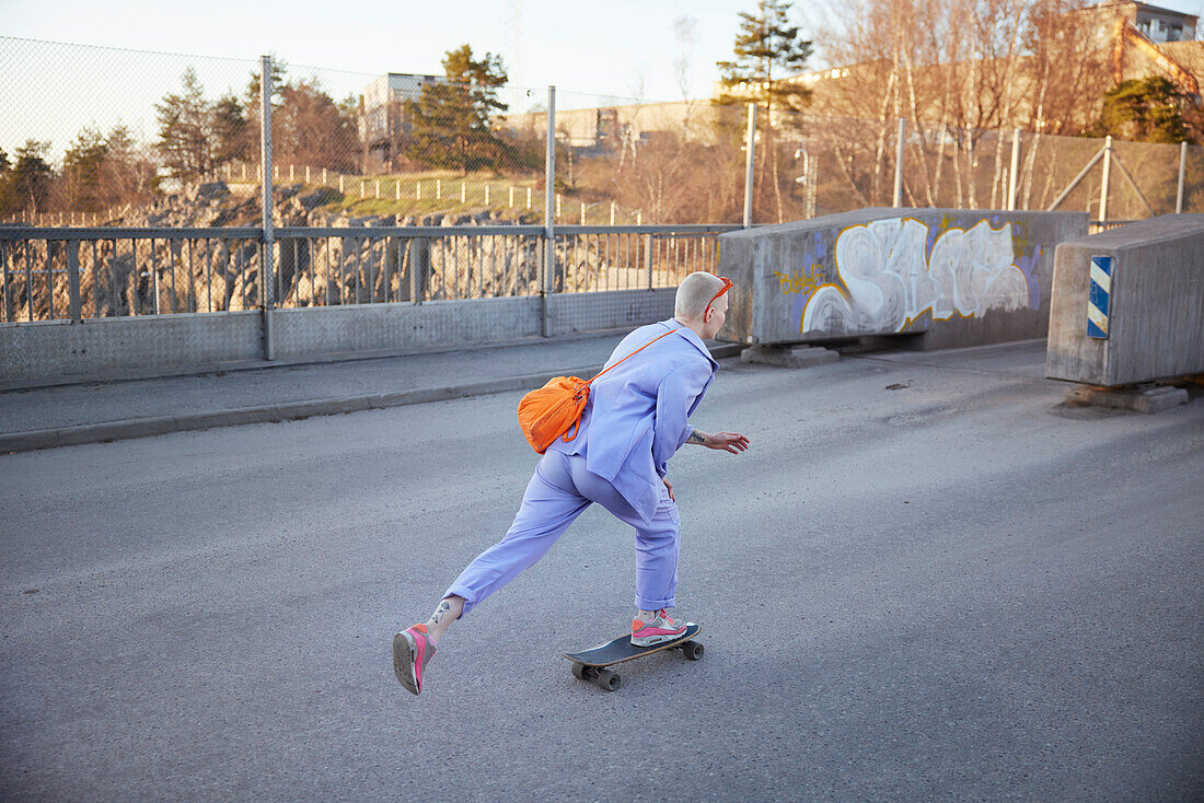 Rear view of young woman skateboarding