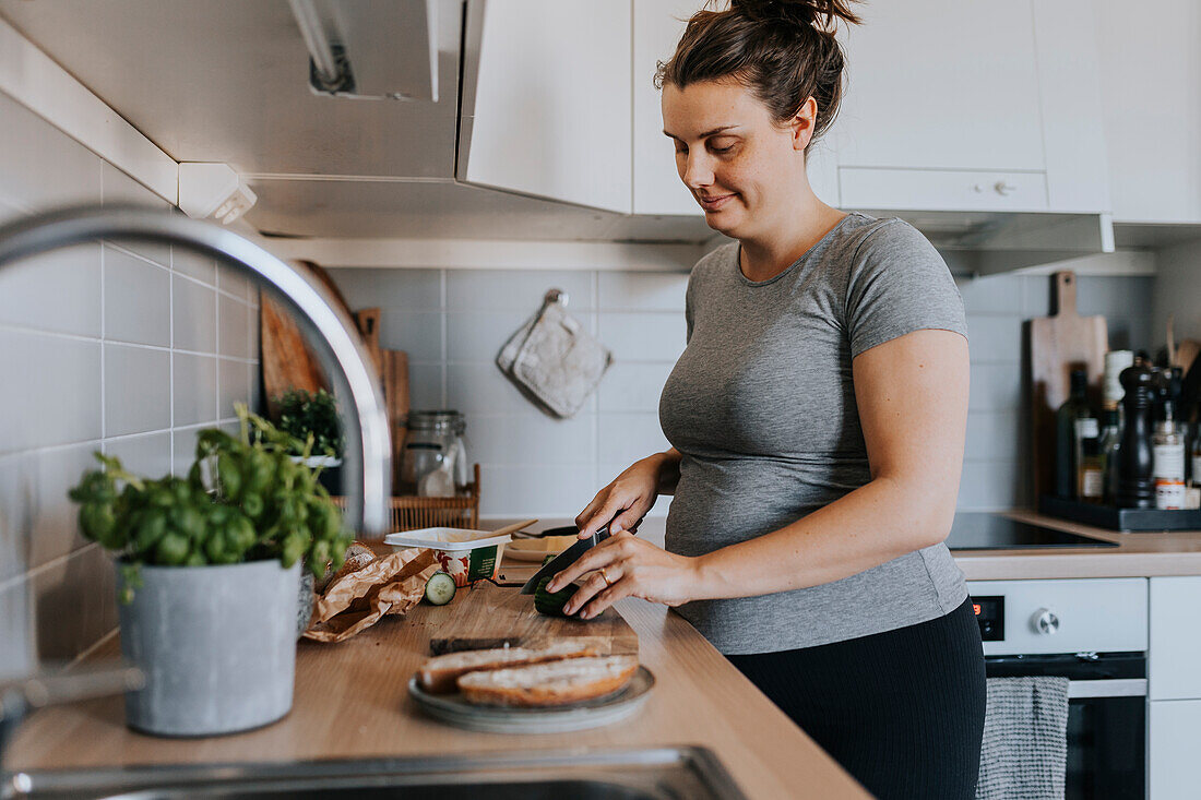 Schwangere Frau macht Frühstück zu Hause