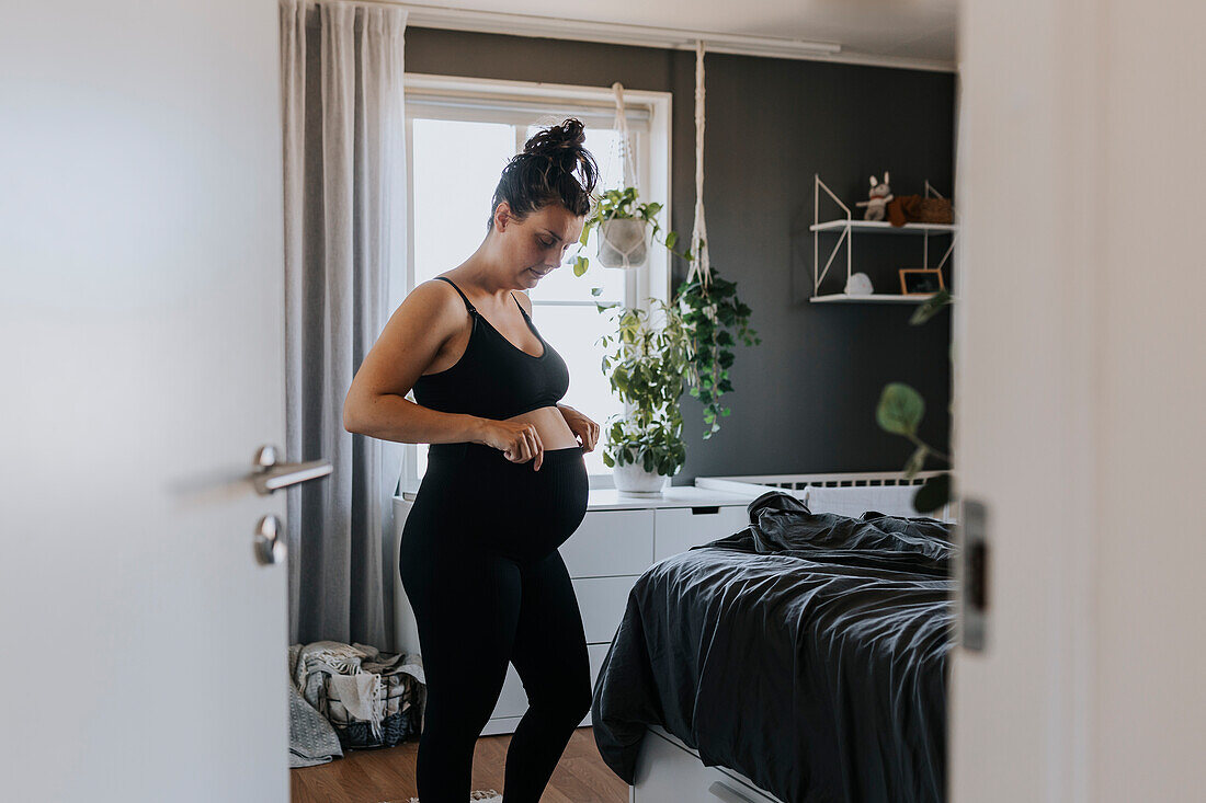 Pregnant woman getting dressed in comfortable clothing