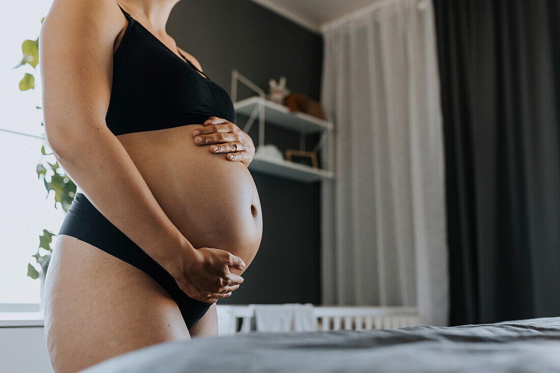 Close-up of pregnant woman touching belly