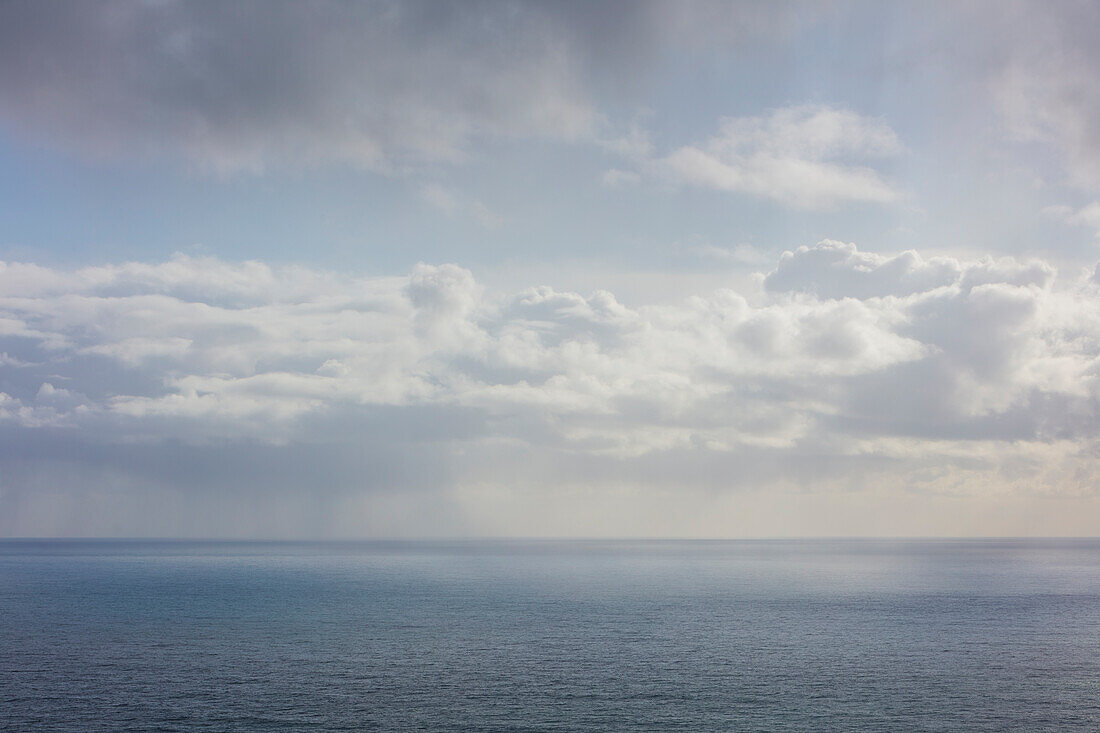 Weiße Wolken am blauen Himmel über dem Pazifischen Ozean in der Abenddämmerung