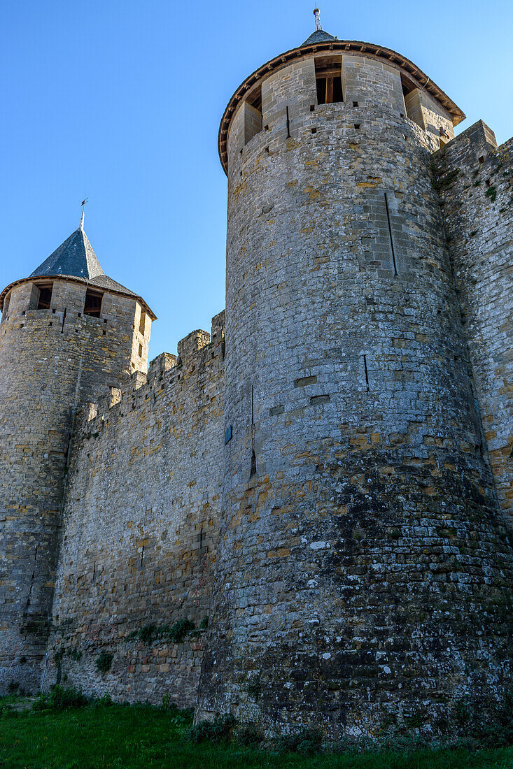 Die mittelalterliche Stadt Carcassonne, Türme mit spitzen Dächern und solide Mauern der befestigten Gebäude, ein Blick von unten.