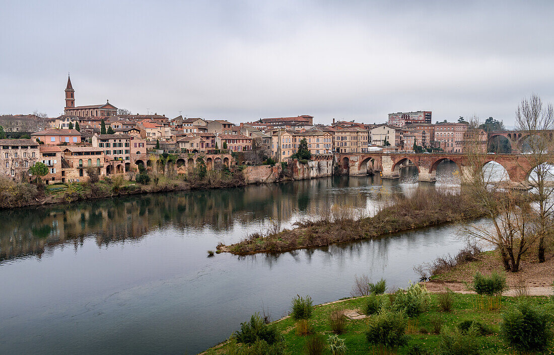 View of Albi, the city and historic buildings from the River Tarn, the Pont Vieux and an island in the stream. 