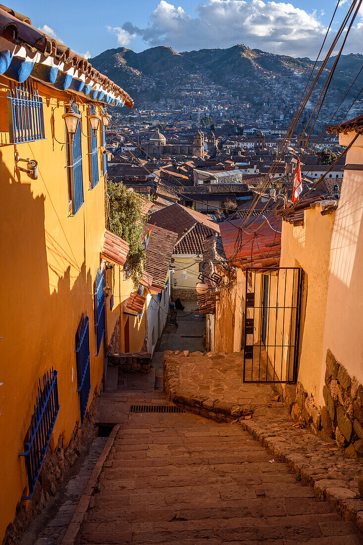 Cusco, a town in the Andes in a valley, steep hillside and view of the historic buildings at the centre. 