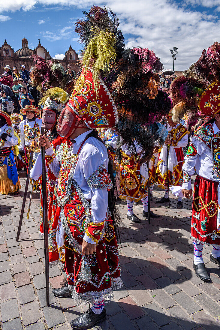 Cusco, a cultural fiesta, people dressed in traditional colourful costumes with masks and hats with feathers. 