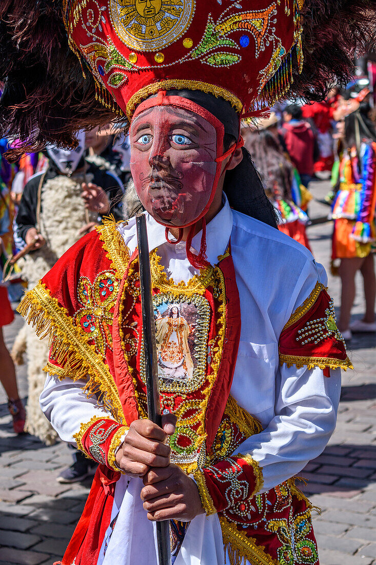 Cusco, ein kulturelles Fest, Menschen in traditionellen bunten Kostümen mit Masken und Hüten mit Federn.