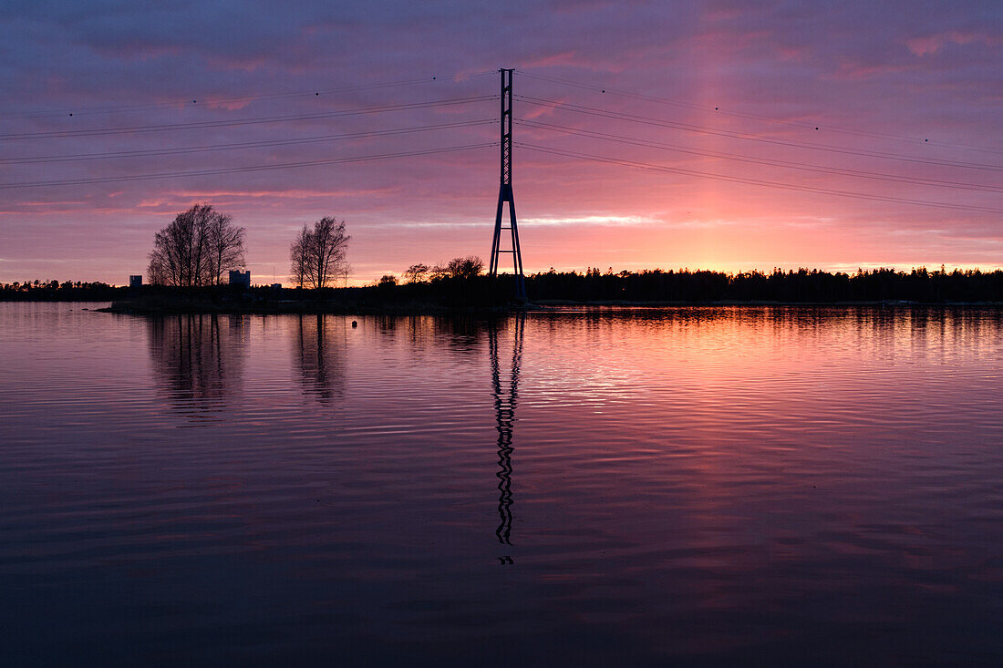 Ein Blick auf einen hohen Mast und Gebäude an der Küste der Inseln bei Helsinki, bei Sonnenuntergang.