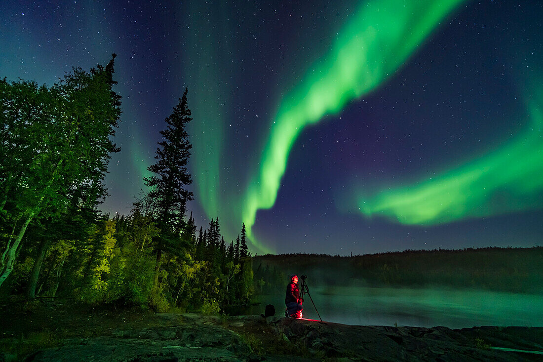 Der Fotograf Stephen Bedingfield fotografiert die Nordlichter an den Ramparts-Wasserfällen am Cameron River, 8. September 2019. Der Große Wagen ist in der Mitte. Die Espenbäume färben sich gerade schön.