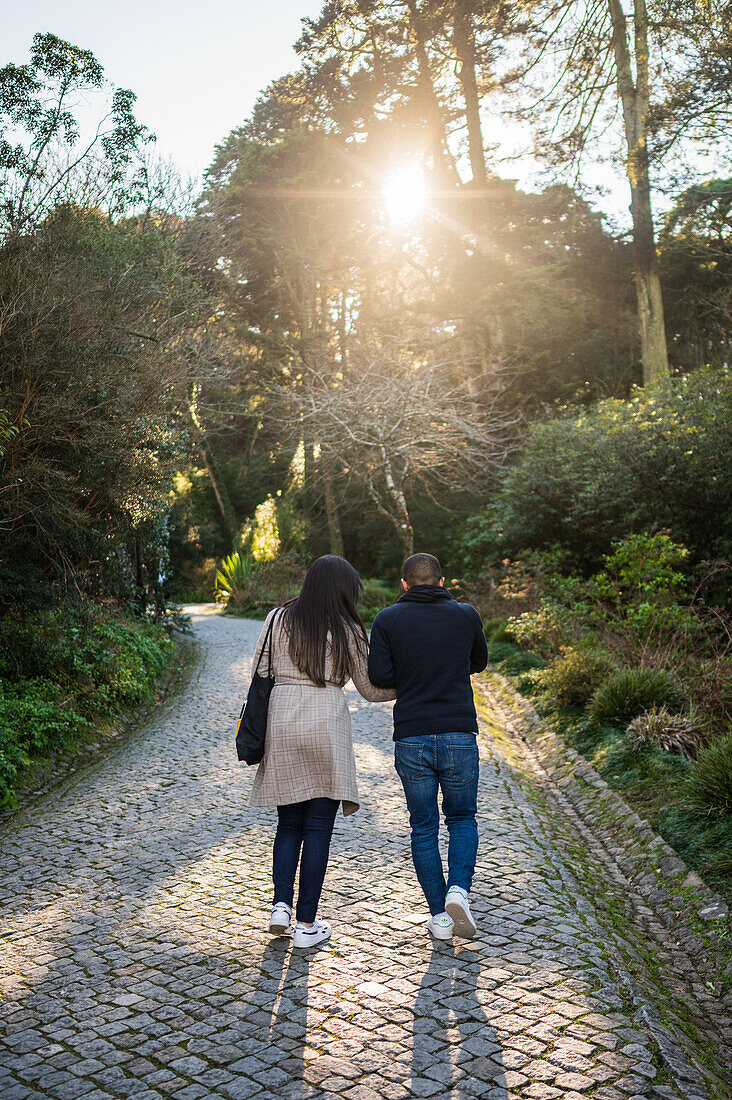 Young couple walking in Park and National Palace of Pena (Palacio de la Pena), Sintra, Portugal
