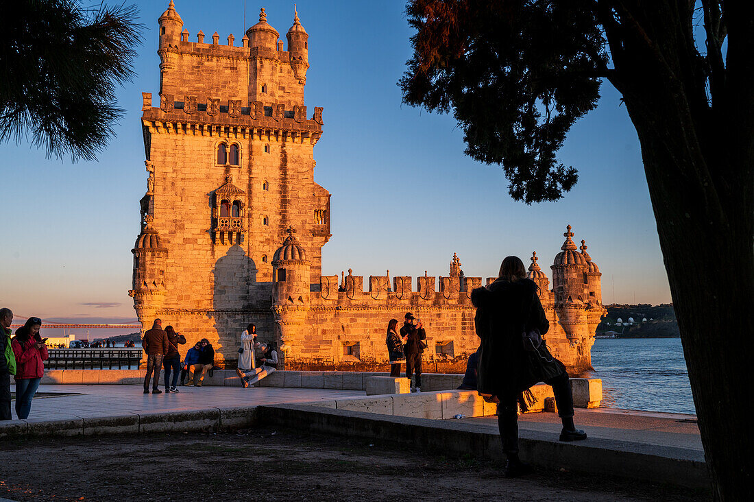 Menschen genießen einen wunderschönen Sonnenuntergang vom Turm von Belem oder dem Turm von St. Vincent am Ufer des Tejo, Lissabon, Portugal