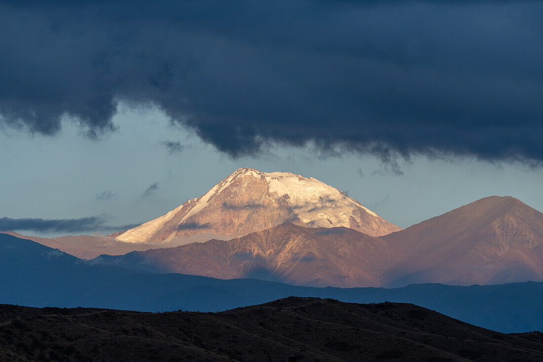 Sunrise light spotlighting the snow-capped Tupungato Volcano in the Andes in Mendoza Province, Argentina.