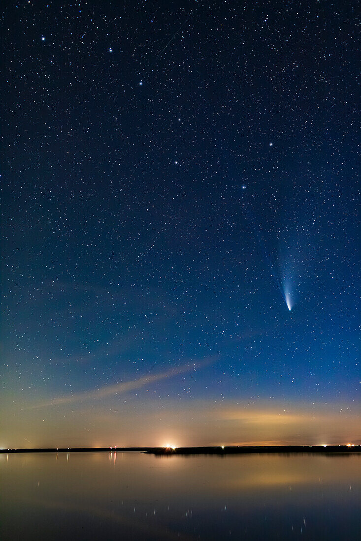 Der Komet NEOWISE (C/2020 F3) über dem stillen Wasser des Crawling Lake in Süd-Alberta in dieser Nacht. Der Große Wagen ist oben zu sehen. Sogar in dieser kurzen Belichtung sind die beiden Schweife, Staub und Ionen, sichtbar. Dies war am 20. Juli 2020. Der blaue Ionenschweif reicht bis in die Schale des Großen Wagens, etwa 20° lang. Sehr beeindruckend!