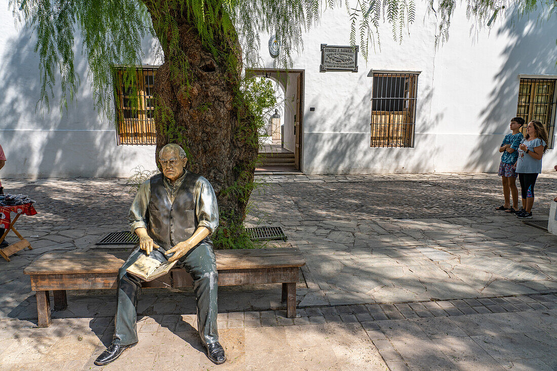 Statue of Domingo Sarmiento sitting on a bench in front of the Birthplace Museum of Domingo F. Sarmiento, San Juan, Argentina.