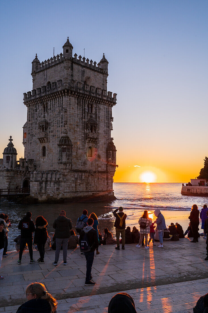 Menschen genießen einen wunderschönen Sonnenuntergang vom Turm von Belem oder Turm von St. Vincent am Ufer des Tejo, Lissabon, Portugal