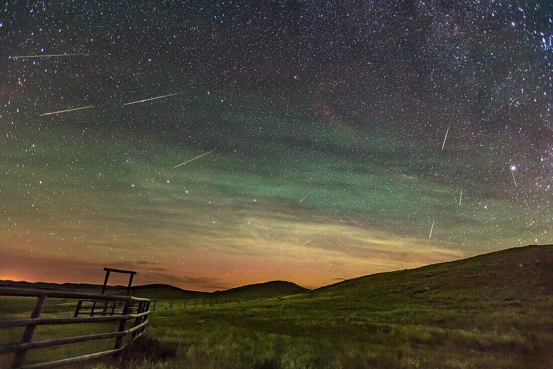The 2016 Perseid meteor shower, in a view looking north to the Big Dipper and with the radiant point in Perseus at upper right, the point where the meteors appear to be streaking from. I shot this on the peak night of the shower, August 11/12 after moonset so the sky was dark and in fact filled with bright airglow, appearing here as bands of green and yellow, mixed with a low-level aurora to the north as well. While it looks like the sky has artificial light pollution, the glows here are natural, from aurora and airglow.