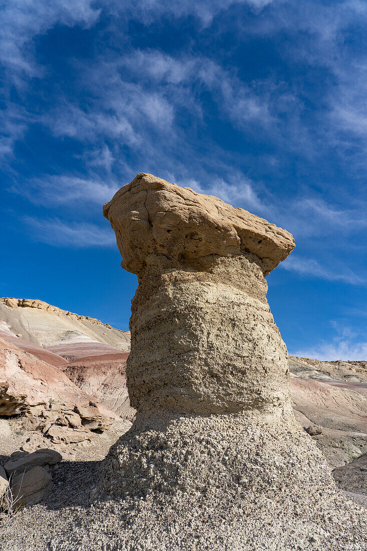 Ein Sandsteinfelsen auf einem Lehm-Hoodoo in den Bentonit-Hügeln der Caineville-Wüste bei Hanksville, Utah.