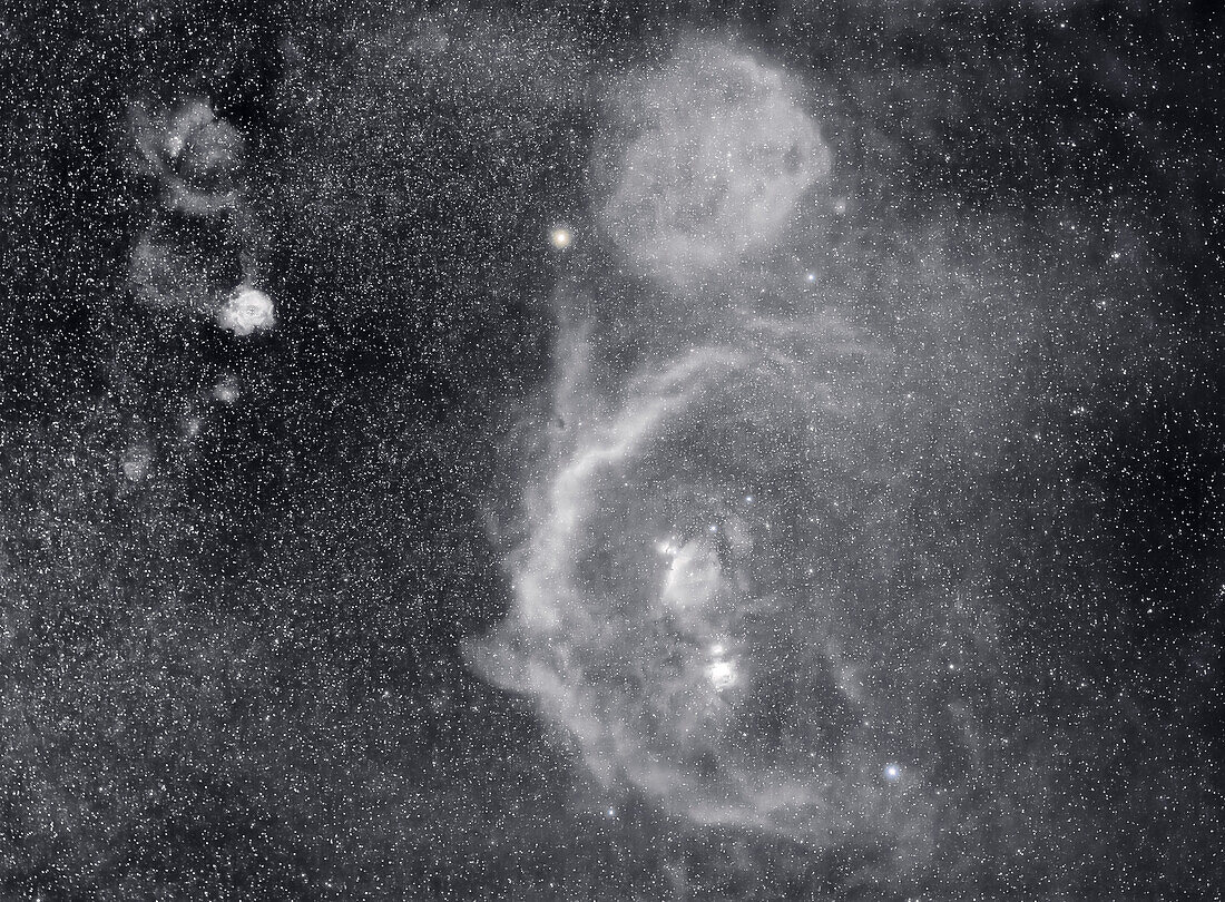 Ein Porträt des Sternbilds Orion, aufgenommen in Monochrom im tiefroten Licht der Wasserstoff-Alpha-Wellenlänge mit einem Schmalbandfilter, um die riesigen Wolken aus interstellarem Gas im und um den Orion hervorzuheben.