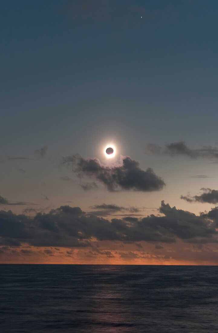July 21, 2009 total solar eclipse near third contact as shadow leaves the horizon and is about to hit the Sun coming toward us. Totality is about to end. Taken from Northern Cook Islands, at sea on m/s Paul Gauguin. Using 20Da and 28-105mm lens at 60mm at f/5 and ISO100. Mercury, blurred ny ship's motion, at top.